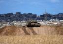 An Israeli tank overlooks the Gaza Strip, as seen from southern Israel on Monday (Tsafrir Abayov/AP)